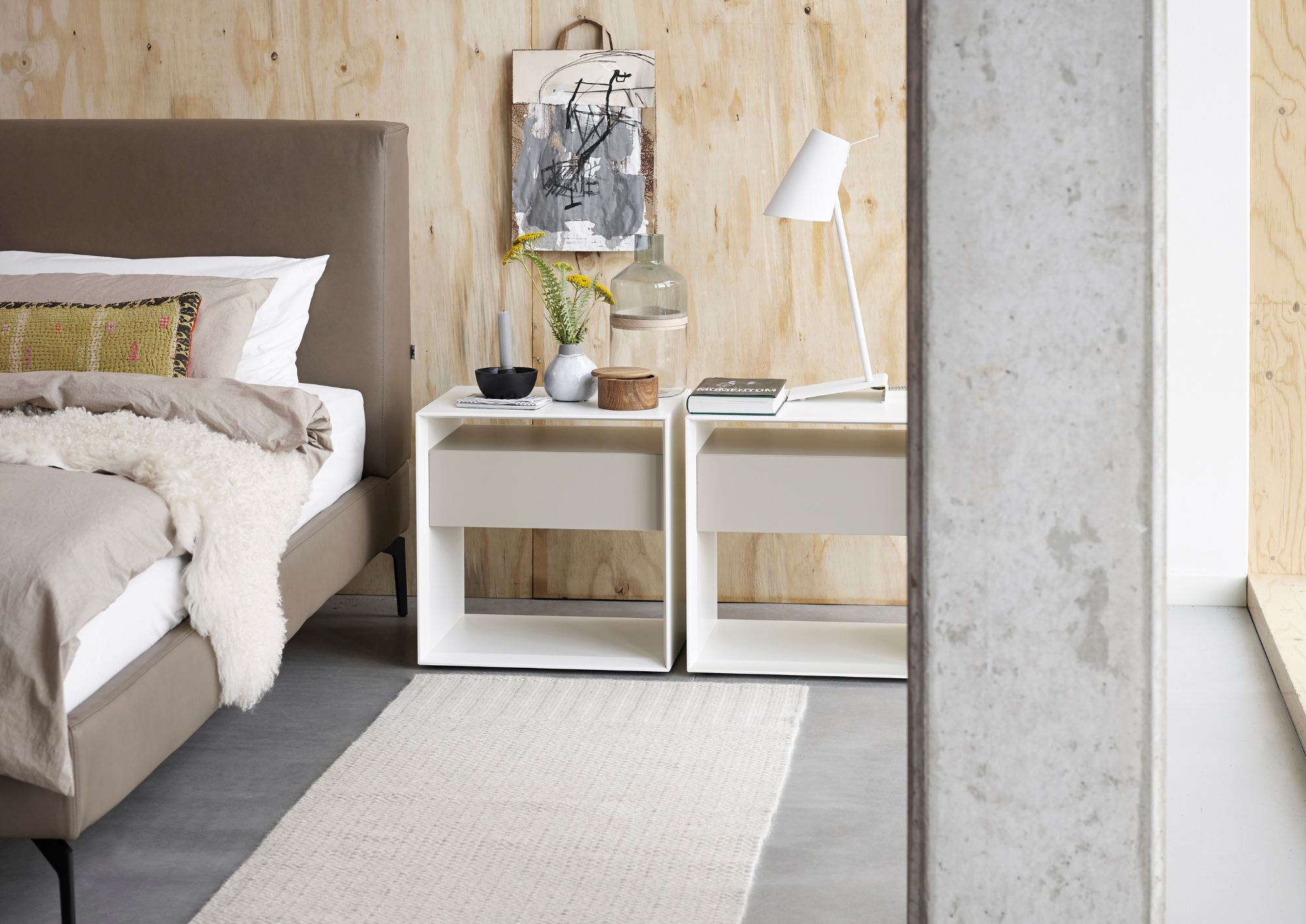 Modernes Schlafzimmer mit weißen Nachttischen und Holzwand