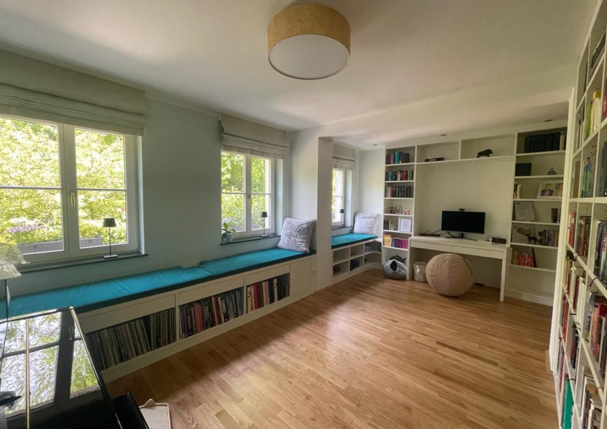 Bibliothekswand mit integriertem Bücherregal und Sitzbank mit Stauraum in einem kombinierten Arbeitszimmer