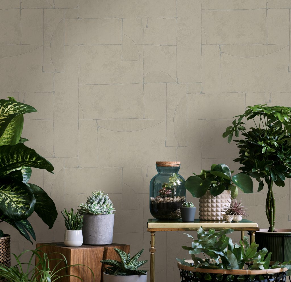 Beige Tapete mit feiner Struktur als moderne Alternative zu Raufasertapeten, dekoriert mit Pflanzen und Wohnaccessoires.