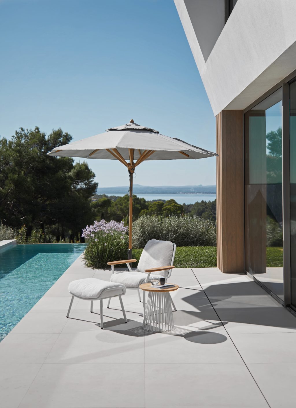 Moderne Gartenmoebel Leipzig mit Loungesessel, Beistelltisch und Sonnenschirm auf Terrasse mit Pool